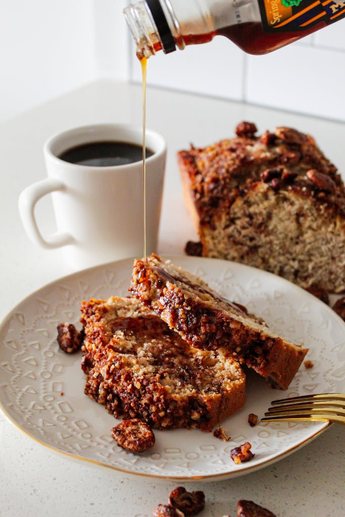 Artisanal banana bread with syrup and coffee, perfect for breakfast delight.