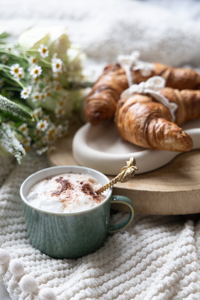 Warm morning setup with delicious croissants and frothy coffee.